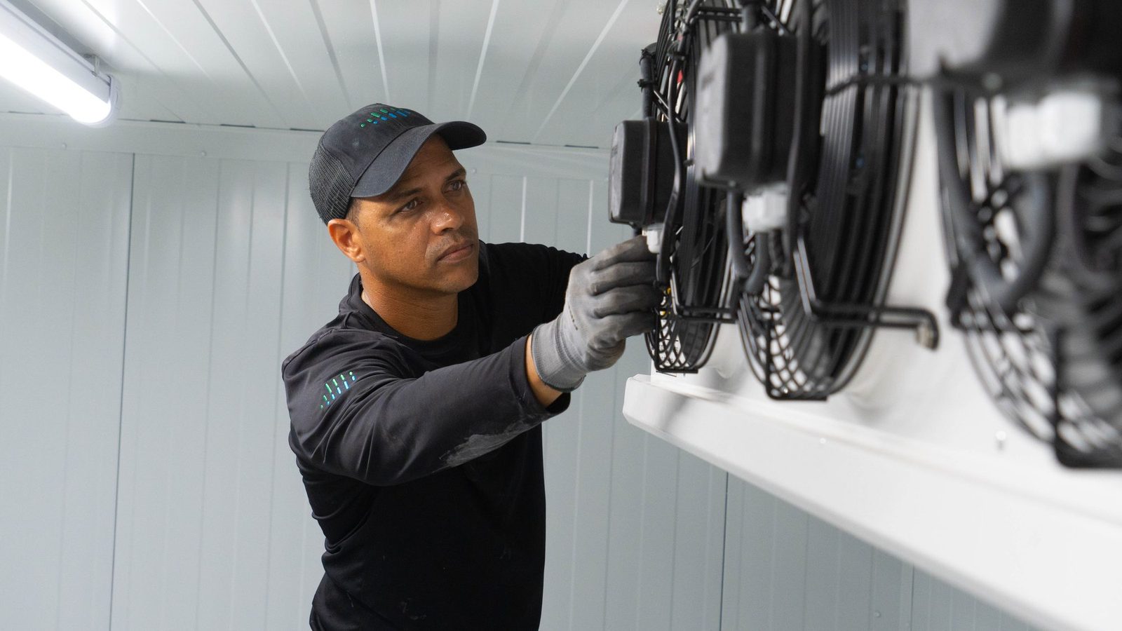 Technician servicing the evaporator fans inside a walk-in freezer